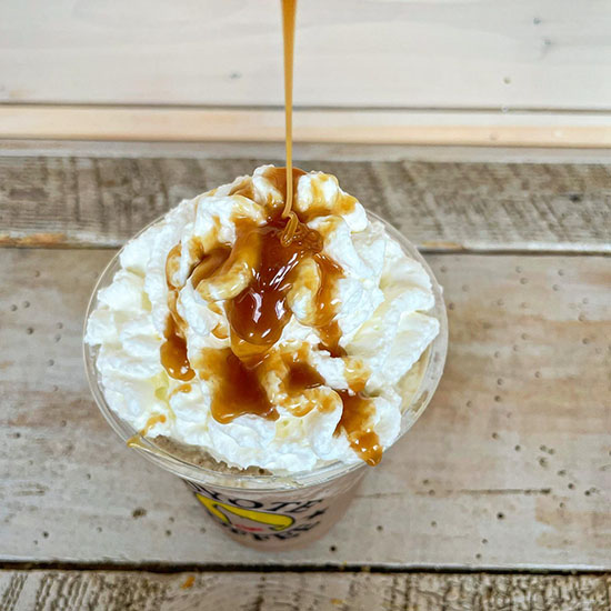 caramel being poured on a frappuccino